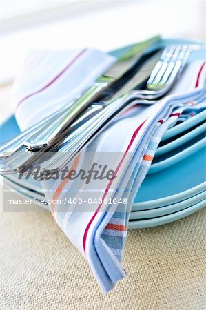 Table setting with stack of plates and cutlery