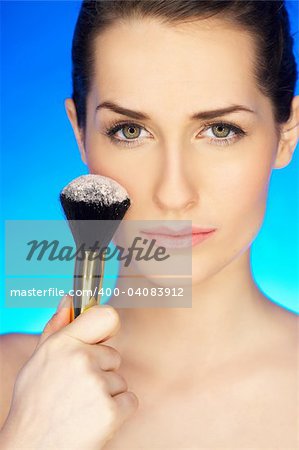 Portrait of beautiful woman with cosmetics brush