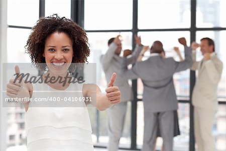 Smiling business woman showing team spirit on from of Business Team