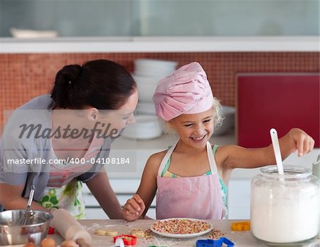 Young mother in kitchen teaching child how to cook