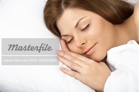 Portrait of the beautiful sleeping woman in white bed