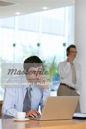 Confident young business man working on laptop