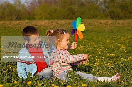 Kids playing on the spring meadow full of flowers