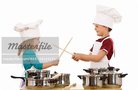 Kid chefs having fun dueling with wooden spoons - isolated