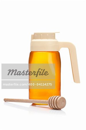 Honey pitcher and wooden drizzler, reflected on white background. Focus at front and shallow depth of field