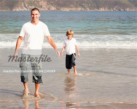 Young father and son playing on a beach