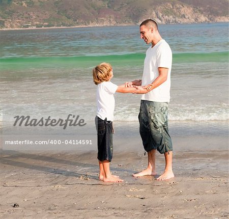 Young father and son playing on a beach