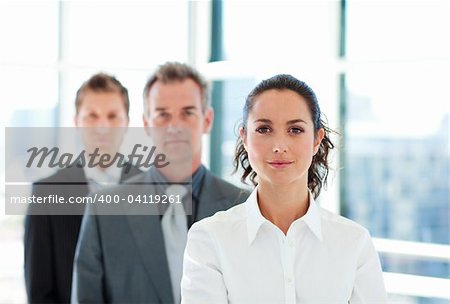 Serious young businesswoman in front of her team