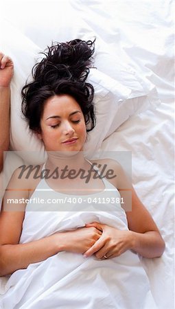Beautiful brunette woman sleeping in bed