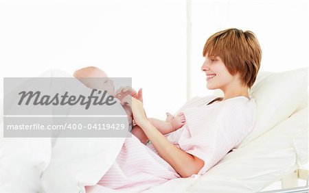 Mother playing with her baby son in hospital