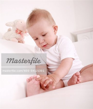 Portrait of cute newborn playing with his toe