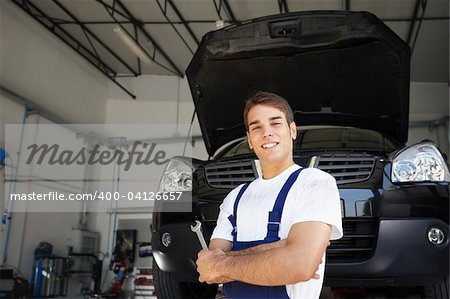 portrait of female client with arms folded in auto repair shop.