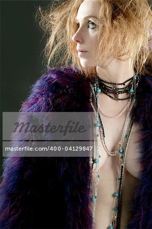 Beautiful sexy redhead woman with feather coat and jewelry, over black