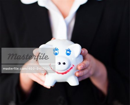 Young businesswoman holding a funky piggy bank