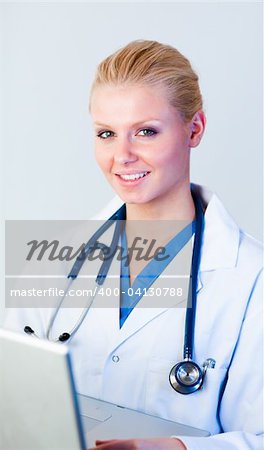 Young Doctor working on a laptop looking at camera