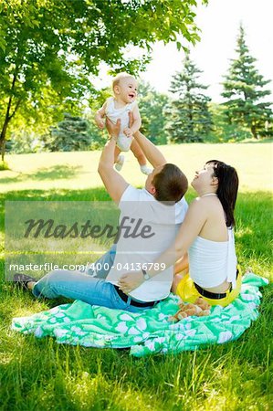 Happy parents playing with their baby in the park