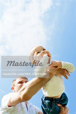 Baby boy flying on his dad's hands