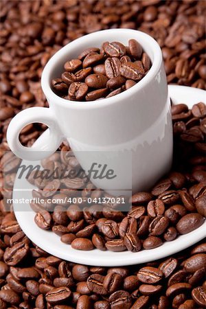 White coffee cup and saucer with roasted beans
