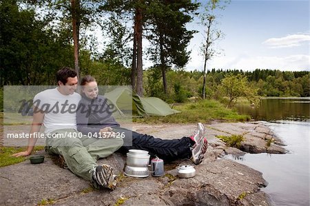 A couple camping and eating outdoors