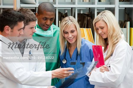 Group of doctors speaking in a hospital office and smiling