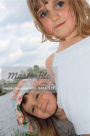 adorable happy girls friends outdoor on the riverbank