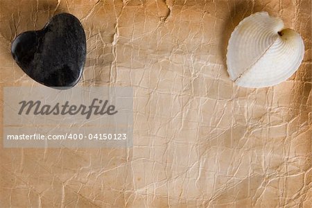 Stone Heart and heart shaped seashell on old foxed paper