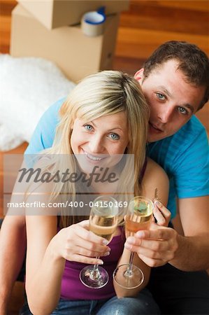 Lovers celebrating new house with champagne smiling at the camera
