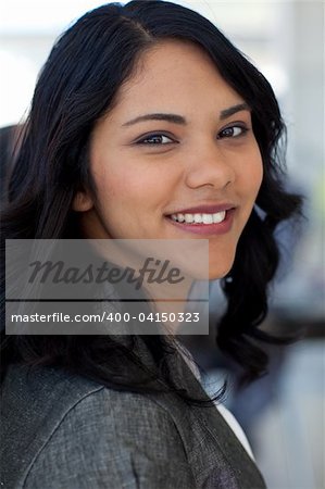 Portrait of friendly ethnic businesswoman in office smiling at the camera