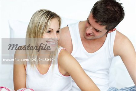 Young lovers together sitting on bed