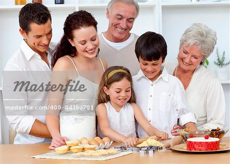 Parents and granparents looking at children baking in the kitchen
