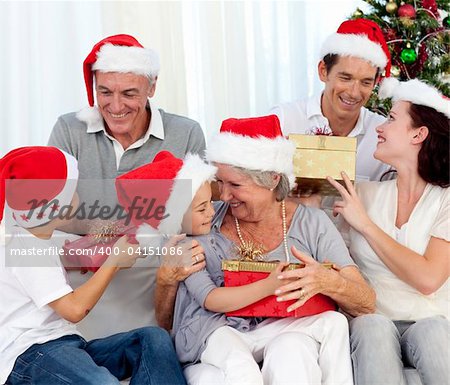 Happy family with Christmas gifts in sofa at home