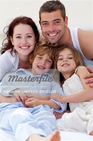 Smiling family playing in bed