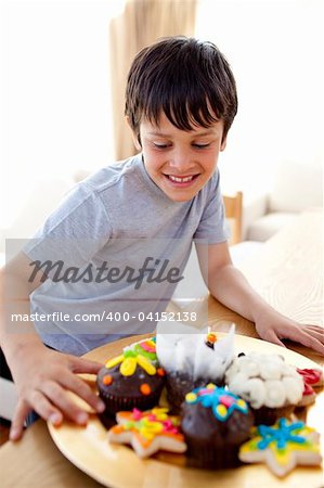 Happy boy looking at colorful confectionery at home