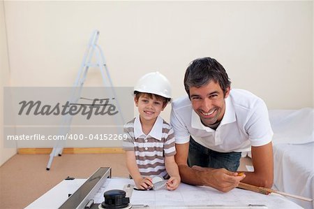 Smiling dad and little boy studying architecture at home