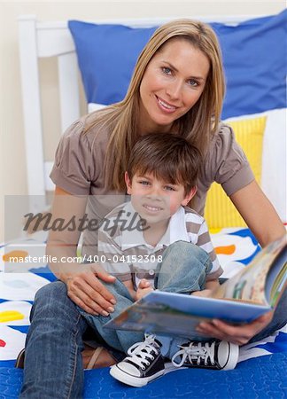 Attractive mother reading a book with her son in bed