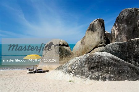 two sun loungers under yellow umbrella on white sand beach of koh samui thailand