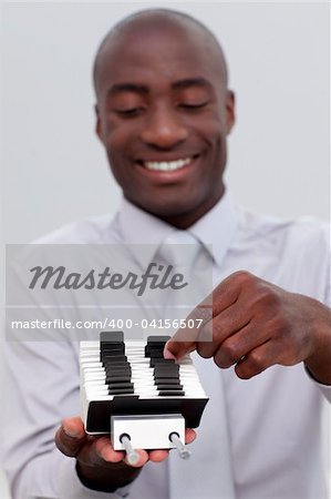 Afro-American businessman looking at an index holder in the office