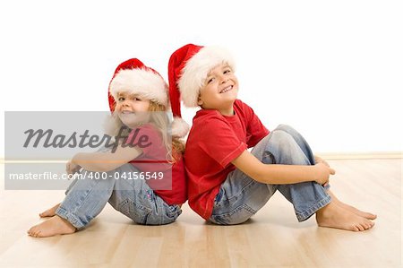 Happy laughing christmas kids sitting on the floor - isolated