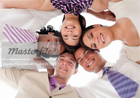 Smiling business team in a circle with heads together against white background