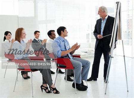 Business people applauding at the end of a conference in the office