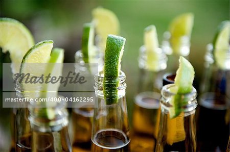 Close up image of multiple beer bottles with limes inserted