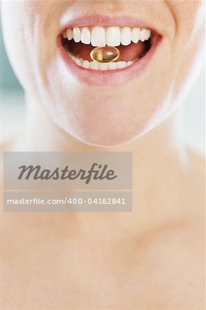 closeup of woman eating pill. Copy space