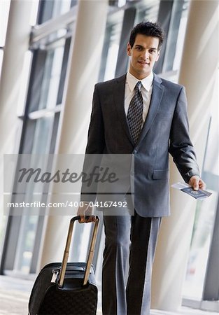 Young businessman with passport and luggage.  Vertically framed shot.
