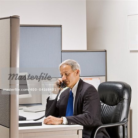 Businessman talking on telephone at desk