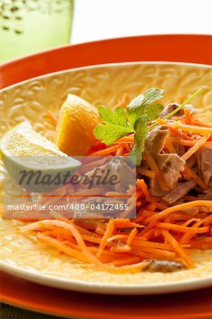 Lemon, lime, carrot, meat and potherb on plate
