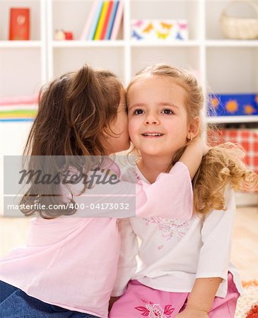 Little girls sharing a delightful secret