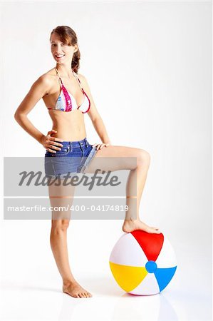 Beautiful young woman posing in bikini with a beach ball