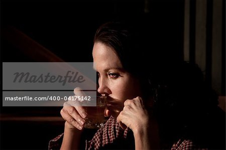 Alcoholic woman with glass of clear liquor