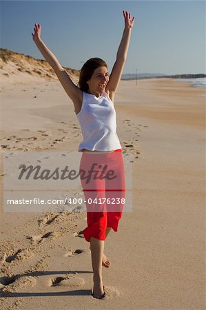 Happy young woman running on the beach