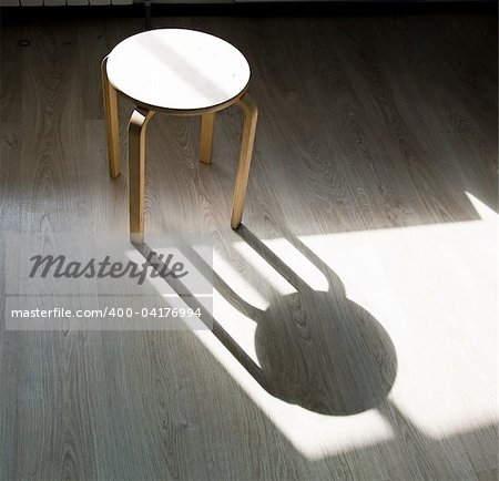 the  stool and shadow on the parquet floor